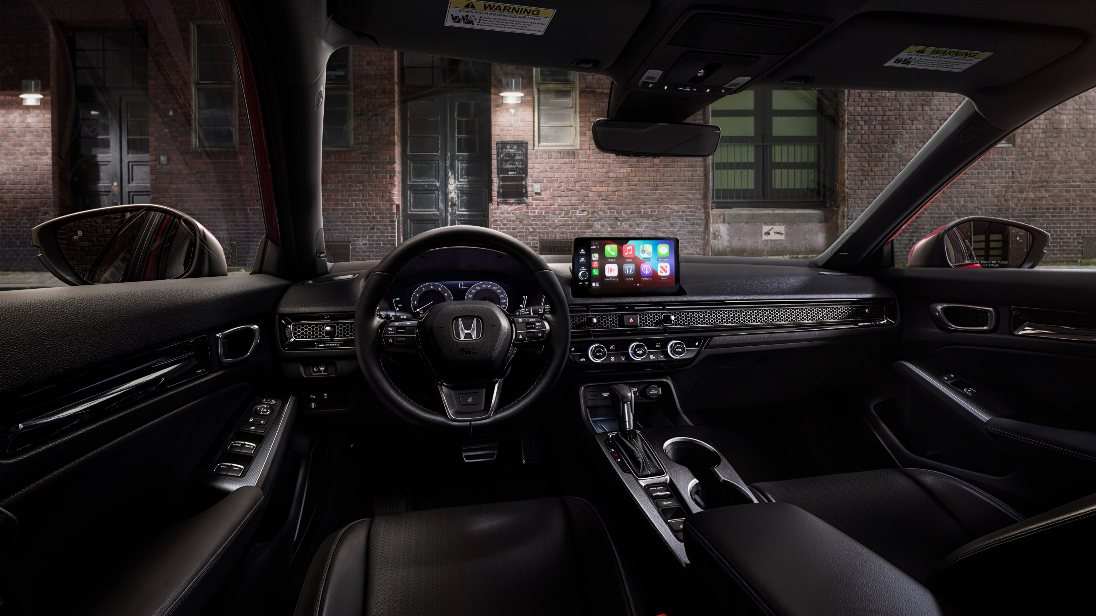 Interior view from Honda Civic Hatchback driver's seat looking out to a brick building