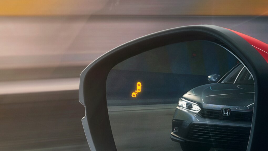 View from red Honda Civic Hatchback driver’s seat of a black car reflected in the side mirror