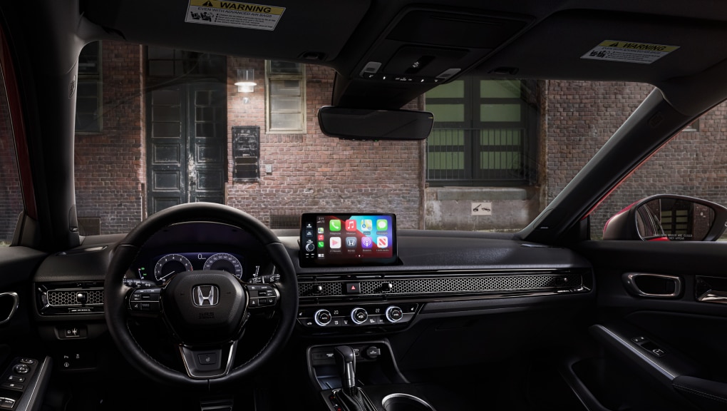 Interior view from Honda Civic Hatchback driver's seat looking out to a brick building