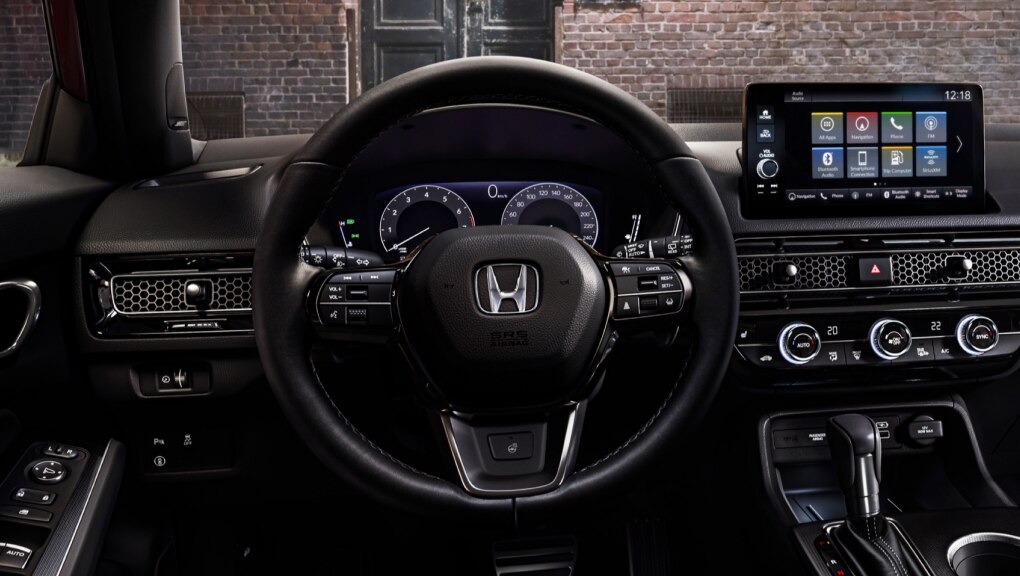 Interior view from Honda Civic Hatchback driver's seat looking out to a brick building