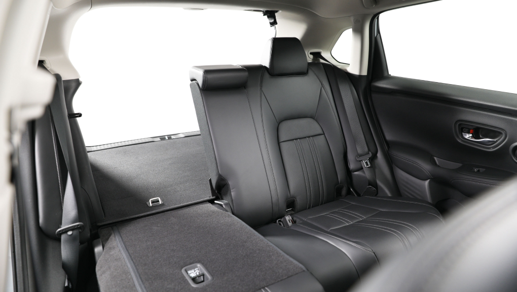 Interior view of the 2022 Honda HR-V, with rear seat folded down, storing a lamp and rug. 