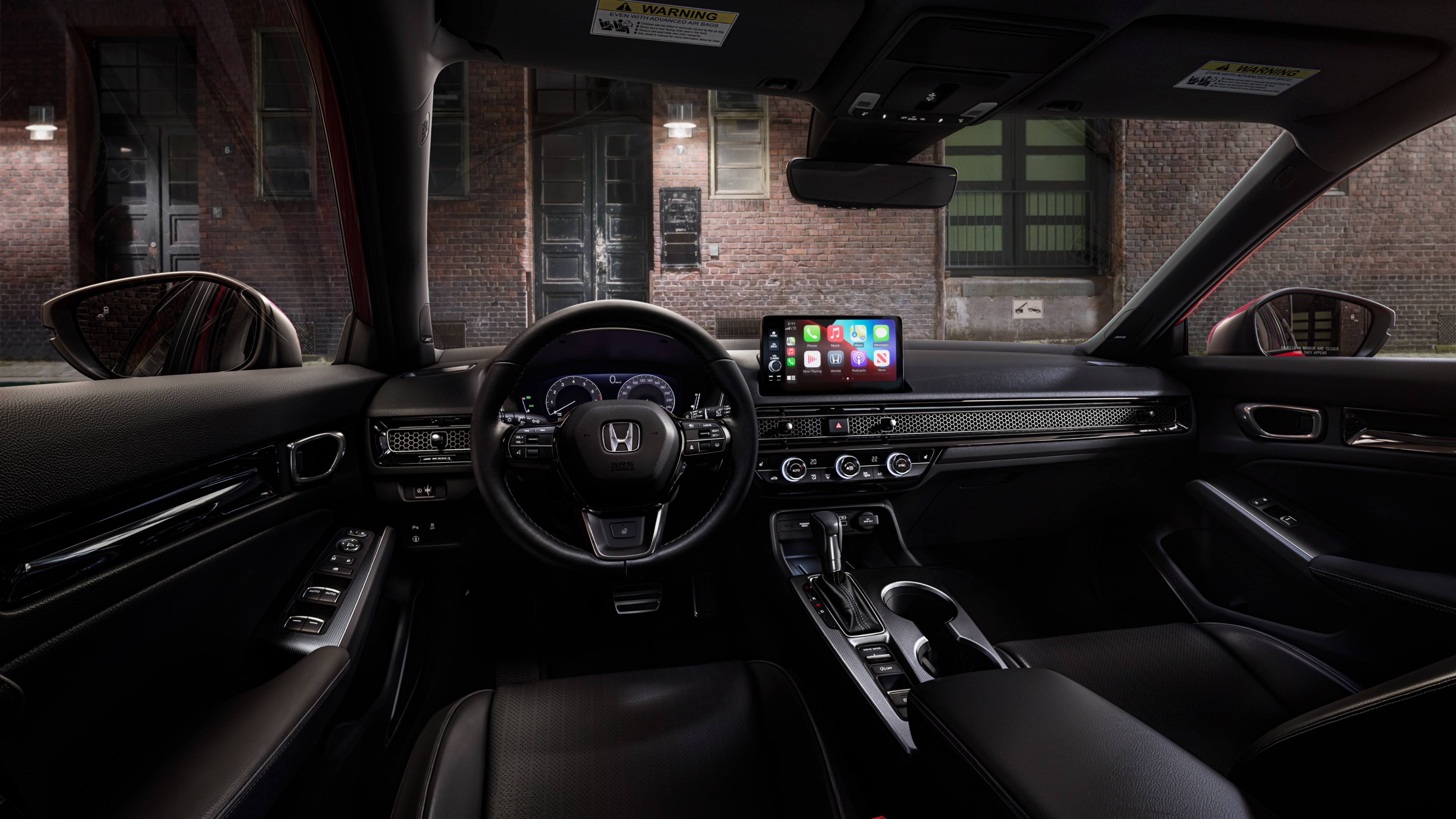Interior view from Honda Civic Hatchback driver's seat looking out to a brick building