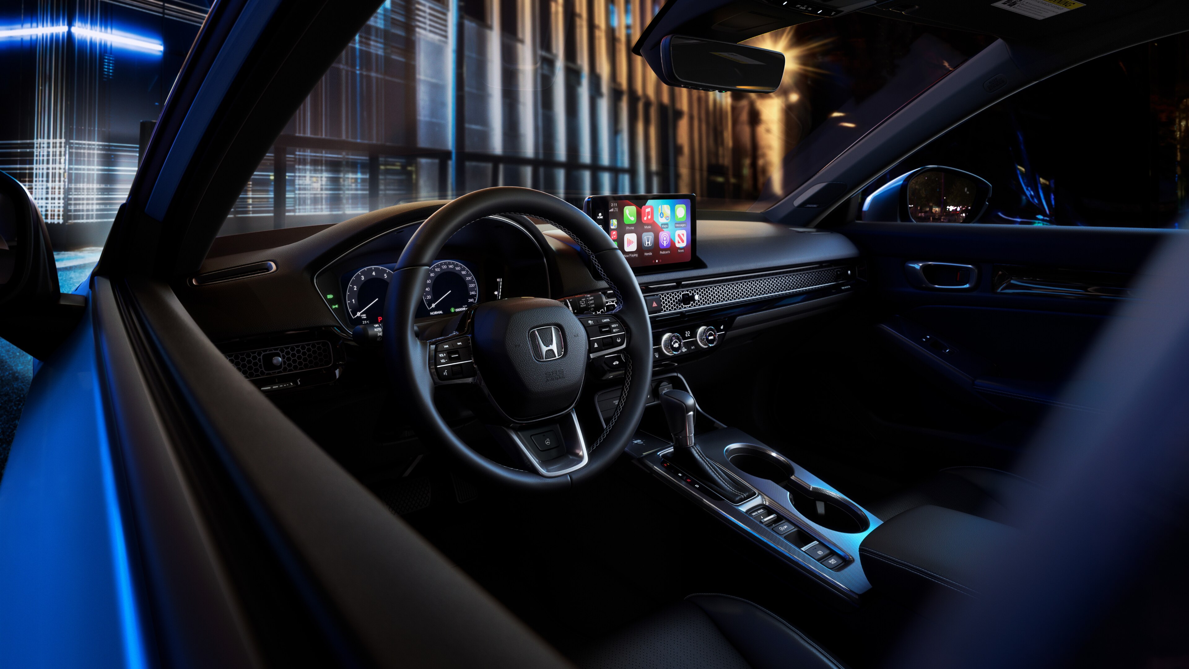 Blue Honda Civic Hatchback steering wheel and windshield through the driver’s-side window